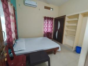 a small room with a bed and a chair at Namitha guest house in Hampi