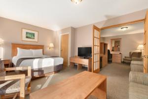 una camera d'albergo con letto e TV di Days Inn & Suites by Wyndham Thunder Bay a Thunder Bay