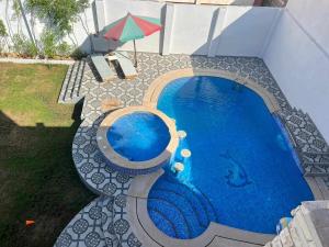 a swimming pool with an umbrella next to a building at الشاطئ الفضي in El-Shaikh Mabrouk
