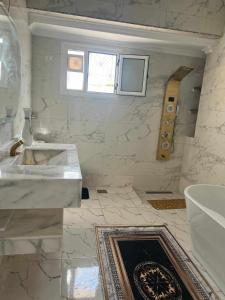 La salle de bains blanche est pourvue d'un lavabo et d'une baignoire. dans l'établissement الشاطئ الفضي, à El-Shaikh Mabrouk