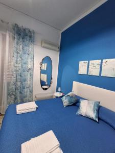 um quarto azul com uma cama e um espelho em La Casa di Giovy em Palermo