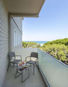 a balcony with two chairs and a table and the ocean at Hotel Cristallo in Giulianova