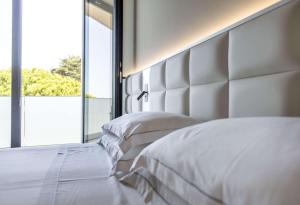 a bedroom with two white beds and a large window at Hotel Cristallo in Giulianova