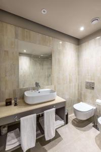 a bathroom with a sink and a toilet and a mirror at Hotel Cristallo in Giulianova