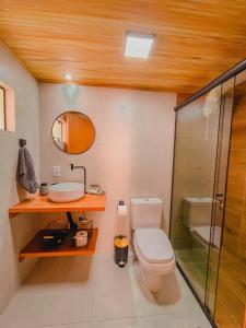 a bathroom with a toilet and a sink and a shower at Shangri La Casas e Studios in Praia do Rosa +164 photos