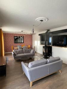 a living room with couches and a brick wall at Maison familiale et cosy in Argenteuil