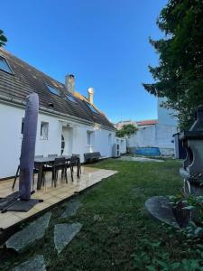 a house with a table and chairs on a deck at Maison familiale et cosy in Argenteuil