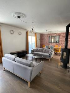 a living room with couches and a brick wall at Maison familiale et cosy in Argenteuil
