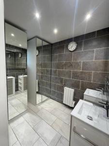 a bathroom with a sink and a clock on the wall at Maison familiale et cosy in Argenteuil +9 photos