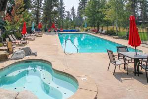 een zwembad met stoelen en een tafel en parasols bij Spacious McCall Home with Private Lake Access! in McCall