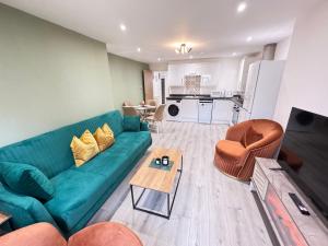 a living room with a green couch and a table at The Phantom Apartment 1 minute walk to JR, Churchill Manor Nuffield Hospitals Oxford B Uni, Sleeps 5 Guests comfortably very modern 2 rooms 3 bathrooms Private Garden in Oxford