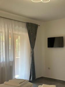 a bedroom with a curtain and a tv on a wall at Pensiunea Casa Suciu in Cugir +18 photos