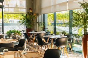 安塔利亚Four Points Flex by Sheraton Antalya Lara的有桌椅和大窗户的餐厅