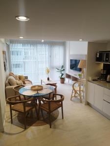 Una cocina y una sala de estar con mesa y sillas. en Altamar, en Mar del Plata