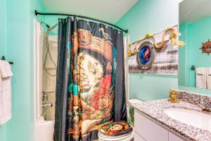 Un baño con cortina de ducha en una habitación con paredes azules. en Pirate Escape Near Rainbow Springs State Park!, en Citrus Springs 18 fotos más