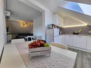 Una cocina con una mesa con un bol de fruta encima. en Green Hill Apartments, en Žirovnica