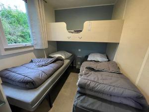 two bunk beds in a room with a window at Le N26 - Bungalow Climatisé proche Europa-Park in Boofzheim