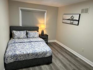a bedroom with a bed and a lamp on a table at Treasure Haven Near Tourism Barrie in Barrie