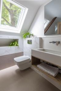 a bathroom with a toilet and a sink and a window at The Loft in Faygate