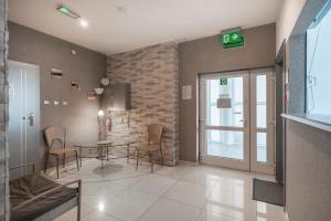 a lobby with a table and chairs in a building at Keja Aparts - 03 Gdynia Centrum in Gdynia