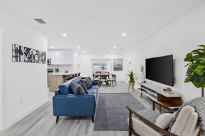 un soggiorno con un divano blu e una TV di Modern villa in Design District ! a Miami