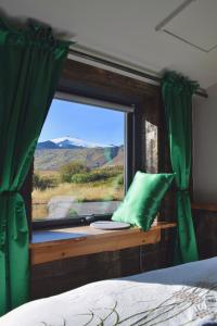 una camera da letto con finestra con tenda verde di The Holy Ram Farm-Hotel a Snæfellsbær Altre 16 foto