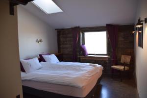 una camera da letto con un letto grande con una finestra di The Holy Ram Farm-Hotel a Snæfellsbær