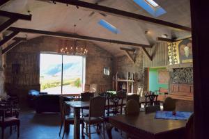 una sala da pranzo con tavoli e sedie e una grande finestra di The Holy Ram Farm-Hotel a Snæfellsbær
