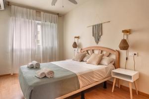 阿勒纳勒斯德尔索尔Dunesunbreak Arenales的卧室里有一张大床，床上铺着毛巾。