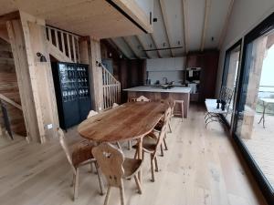 ein Esszimmer mit einem Holztisch und Stühlen in der Unterkunft Chalet luxe avec jacuzzi, sauna, 8 ch, La Plagne Montalbert - FR-1-181-2718 in Hermillon