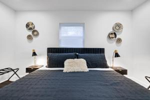 una camera da letto con un letto blu con due lampade e orologi di Modern villa in Design District ! a Miami