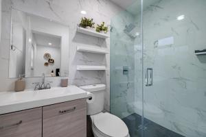 un bagno con wc e doccia in vetro di Modern villa in Design District ! a Miami Altre 60 foto