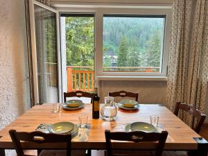 a dining room table with a view of a window at Central recently renovated apartment - Casa Tre Pini in Madonna di Campiglio