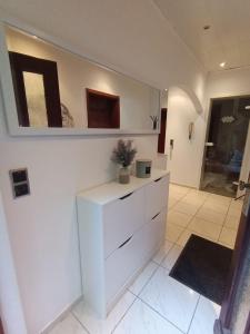 una cucina bianca con cassettiera e specchio di Relaxe Wohnung Bergstraße HP a Ober-Laudenbach