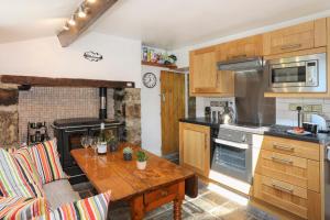 Una cocina con gabinetes de madera y una mesa de madera. en Tan Meredydd, en Nantlle 18 fotos más