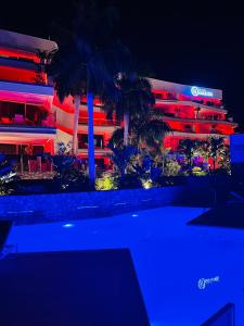 a building lit up in red and blue at night at Grand Horizon Luxury Boutique Apartments in Puerto Rico de Gran Canaria