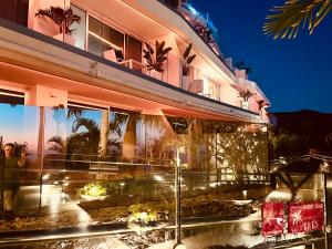 a building with a fountain in front of it at night at Grand Horizon Luxury Boutique Apartments in Puerto Rico de Gran Canaria
