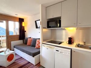a small apartment with a kitchen and a couch at Agréable 2 pièces avec balcon, internet, ménage et linge inclus - FR-1-634-102 in Morzine