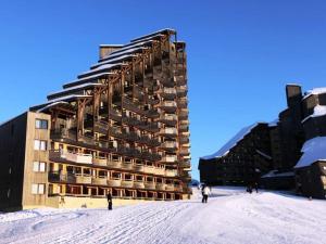a building in the snow with people standing in front of it at Agréable 2 pièces avec balcon, internet, ménage et linge inclus - FR-1-634-102 in Morzine
