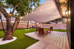 un patio con tavolo e sedie sotto un ombrellone bianco di Modern villa in Design District ! a Miami