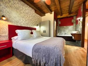 a bedroom with a large bed and a bathroom at Apartamentos Spa Casco Histórico de Isla in Isla