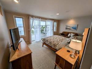 a bedroom with a bed and a tv and a couch at Lake Front Retreat on Flathead in Bigfork