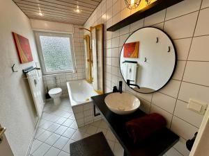 a bathroom with a sink and a mirror at KA-City, 3 Zi, 75qm, Parken, Balkon, WLAN, Netflix ruhige Lage in Karlsruhe +9 photos