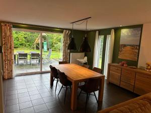a kitchen with a wooden table and a dining room at Vakantiehuisje drenthe gasselterveld in Gasselte