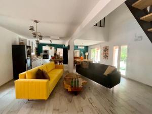 卡尔卡松Le Mas Victoria - Chambres d'hôtes avec table d'hôtes-Parking privé ferme的客厅里有一张黄色的沙发和一张桌子