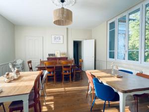 a dining room with wooden tables and chairs at Maison de maître 15 personnes in Lierval