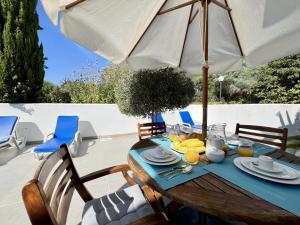 une table avec une nappe bleue et un parasol dans l'établissement Vilamoura Club Villa 1 With Pool by Homing, à Vilamoura