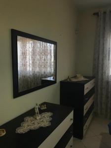 a bedroom with a dresser and a mirror on the wall at A Home Away From Home in Vlorë