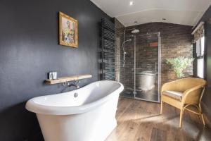 ein Badezimmer mit einer weißen Badewanne und einem Stuhl in der Unterkunft Host & Stay - Garnet Street in Saltburn-by-the-Sea