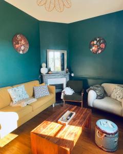 a living room with two couches and a table at Maison de maître 15 personnes in Lierval